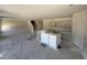 Kitchen with center island wrapped in plastic and stairs going to the second floor at 18 W Emily Gardens Dr, Selma, NC 27577