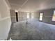 A spacious living room under construction with gray walls, white trim, a back door and lots of windows at 18 W Emily Gardens Dr, Selma, NC 27577