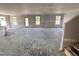 A large living room under construction with gray walls, white trim, a back door and lots of windows at 18 W Emily Gardens Dr, Selma, NC 27577
