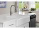 Close up of kitchen island and sink, including stainless faucet, white cabinetry, and view to outside at 2011 Cross Bones Blvd # 41, Durham, NC 27703