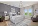 Spacious main bedroom with a gray accent wall, modern furnishings, and large windows with green view at 2011 Cross Bones Blvd # 41, Durham, NC 27703