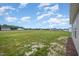 Large backyard showing ample green space with nearby homes under a blue, partly cloudy sky at 21 Trescott St, Smithfield, NC 27577