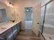Bathroom featuring a dual sink vanity, quartz countertop, and a glass-enclosed shower at 21 Trescott St, Smithfield, NC 27577