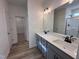 Bathroom featuring a dual sink vanity, quartz countertop, and a glass-enclosed shower at 21 Trescott St, Smithfield, NC 27577