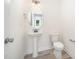 Powder room features a pedestal sink, modern fixtures, and vinyl flooring at 21 Trescott St, Smithfield, NC 27577
