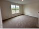 Bright bedroom featuring a large window and plush carpeting at 21 Trescott St, Smithfield, NC 27577