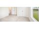 Bright bedroom with a large window, neutral carpet, closet and entry doors at 21 Trescott St, Smithfield, NC 27577