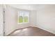 Bright bedroom with a large window offering view of a green outdoor space and hardwood floors at 210 Maxwell Farm Ln, Selma, NC 27576