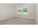 Neutral bedroom with a large window, beige walls and carpet at 210 Maxwell Farm Ln, Selma, NC 27576