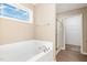 Bathroom featuring a soaking tub, shower with glass door, and window at 212 Tuscany Cir, Princeton, NC 27569