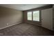 Neutral bedroom featuring plush carpet, two windows for natural light, and a clean, modern aesthetic at 212 Tuscany Cir, Princeton, NC 27569