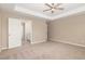 Spacious bedroom with beige carpet; door leading to the bathroom at 212 Tuscany Cir, Princeton, NC 27569