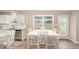 Sunlit dining area showcasing a white table with seating, wood floors, and view to the outdoors at 212 Tuscany Cir, Princeton, NC 27569