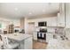 Open-concept kitchen with stainless steel appliances, granite counters, and adjacent living space at 212 Tuscany Cir, Princeton, NC 27569