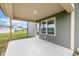 View of a concrete patio with a green home exterior, windows, and access to a door at 212 Tuscany Cir, Princeton, NC 27569