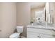 Cozy powder room featuring granite countertops, white cabinetry, and a decorative mirror at 212 Tuscany Cir, Princeton, NC 27569