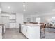 Open concept kitchen with white cabinetry, granite countertops, island seating, and views of the living area at 2153 Monk Dr, Haw River, NC 27258