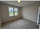 Bedroom with neutral paint, carpet flooring, and a large window at 221 Tee Dr, Selma, NC 27576