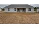 New construction home featuring light gray siding and a covered patio area in a backyard with a barren lawn at 221 Tee Dr, Selma, NC 27576