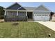 Beautiful craftsman home with a lush lawn, covered porch and an attached two car garage at 221 Tee Dr, Selma, NC 27576