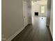 Hallway with wood floors and neutral walls leading to living room with fireplace at 221 Tee Dr, Selma, NC 27576