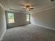 Spacious main bedroom featuring a tray ceiling, plush carpeting, and two large windows at 221 Tee Dr, Selma, NC 27576