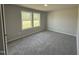 A gray bedroom with two windows and gray carpet at 225 Phil Jack Rd, Dunn, NC 28334