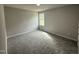 An empty bedroom with gray walls, gray carpet, and a window at 225 Phil Jack Rd, Dunn, NC 28334