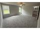 Spacious main bedroom featuring plush gray carpet, a ceiling fan, and natural light at 225 Phil Jack Rd, Dunn, NC 28334