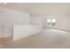 Open loft area with carpet, a half wall, and natural light from windows at 231 Trescott St, Smithfield, NC 27577