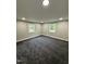 Spacious room with soft carpet, neutral walls, and bright windows at 2316 Radiance Dr, Burlington, NC 27215