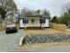 Charming cottage-style home with a cozy front porch, fresh landscaping, and a newly graveled driveway at 2316 Radiance Dr, Burlington, NC 27215