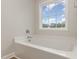 Clean white bathroom features a shower/tub combination and window with a view at 246 Trescott St, Smithfield, NC 27577