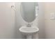 Compact powder room with a pedestal sink and oval mirror at 246 Trescott St, Smithfield, NC 27577