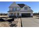 New two-story home featuring a two car garage, stone accents, and newly poured driveway at 253 Trescott St, Smithfield, NC 27577
