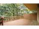 An outdoor wooden deck with railing and partial roof coverage surrounded by lush trees at 2765 Rue Sans Famille, Raleigh, NC 27607