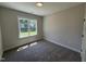 Bright bedroom featuring plush carpeting and a large window for natural light at 28 Bailey-Boykin Rd, Selma, NC 27576