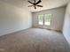 Spacious bedroom with plush carpeting, ample natural light, and a ceiling fan, creating a comfortable and inviting atmosphere at 282 Trescott St, Smithfield, NC 27577