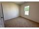 Bright bedroom featuring neutral carpet, a window allowing natural light, and crisp white trim at 282 Trescott St, Smithfield, NC 27577