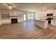 Open concept living room and kitchen with hardwood floors, a fireplace, a kitchen island with granite countertops, and modern appliances at 282 Trescott St, Smithfield, NC 27577