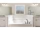 Relaxing bathroom with soaking tub, tiled surround, and elegant vanities at 30 Tee Dr, Selma, NC 27576