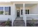 Welcoming front porch with brick steps, white railings, and a stylish front door, offering curb appeal at 30 Tee Dr, Selma, NC 27576