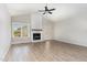 Cozy living room with a fireplace, ceiling fan, hardwood floors and natural light creates a relaxing atmosphere at 30 Tee Dr, Selma, NC 27576