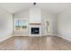 Light-filled living room features a fireplace, hardwood floors, and large windows with scenic views at 30 Tee Dr, Selma, NC 27576