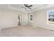 Inviting main bedroom with tray ceiling, fan, and natural light from large windows at 30 Tee Dr, Selma, NC 27576