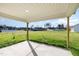View from the covered patio overlooking a large green yard with neighboring houses in the distance at 300 Tuscany Cir, Princeton, NC 27569
