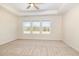 Neutral bedroom with large windows, tray ceiling, and a ceiling fan at 300 Tuscany Cir, Princeton, NC 27569