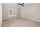 Cozy bedroom with plush carpet, a ceiling fan, and a bright window offering natural light and neighborhood views at 303 E Pope Ave, Kenly, NC 27542