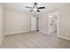 A spacious bedroom features neutral paint, carpet, ceiling fan, and a doorway to the en-suite bathroom at 303 E Pope Ave, Kenly, NC 27542