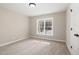 A bedroom is bright with natural light, neutral paint and carpet at 303 E Pope Ave, Kenly, NC 27542